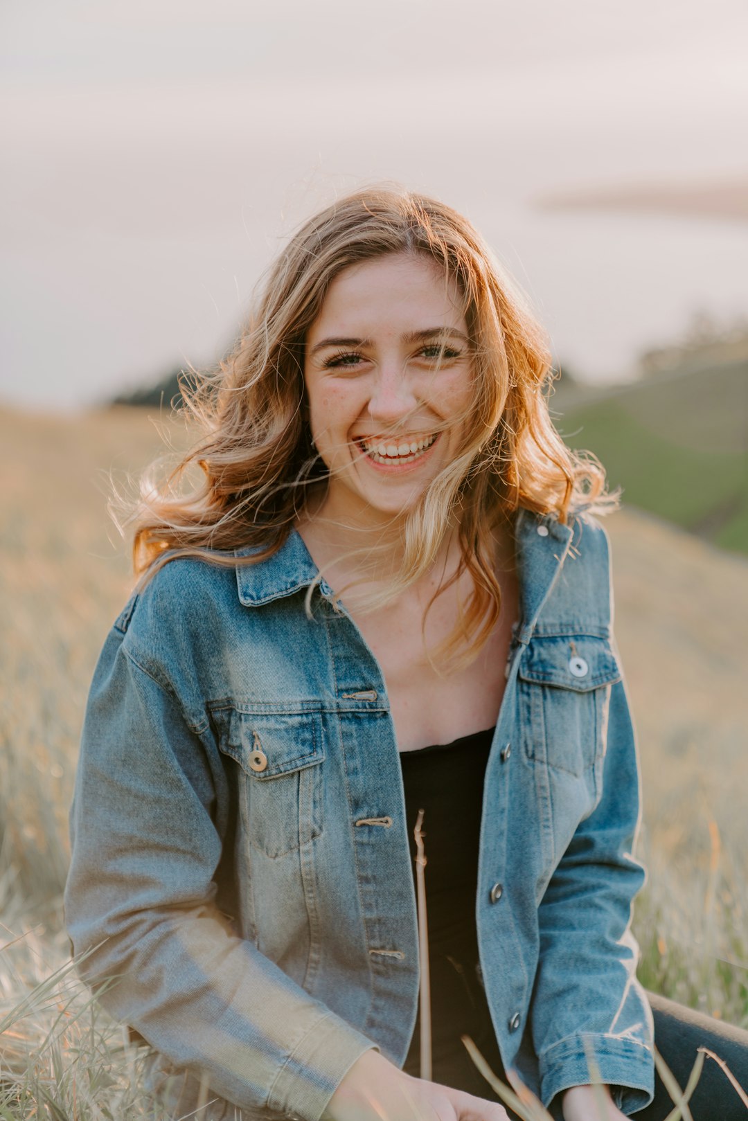 Photo by Slav Romanov smiling woman sitting on grass during daytime